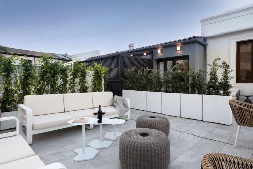eine Terrasse mit weißen Möbeln und Pflanzen in der Unterkunft Coliseum Boutique Apartments in Córdoba