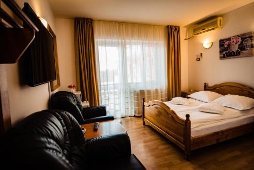 ein Schlafzimmer mit einem Bett und einem großen Fenster in der Unterkunft Pensiune Roua 2 in Arad