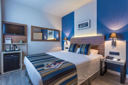 a bedroom with a bed with blue walls at DWO Urban Granada in Granada