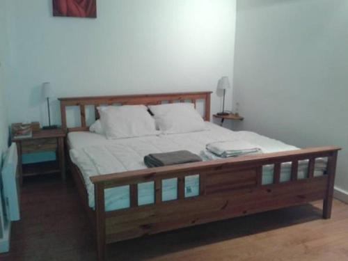 a bedroom with a wooden bed with two pillows at Chambres d'hôtes chez Loulou et Caramel in Magstatt-le-Bas