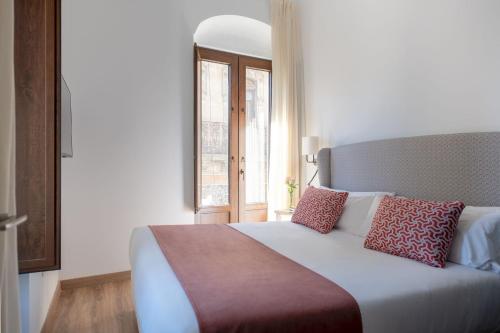 a bedroom with a large bed with a window at Coliseum Boutique Apartments in Córdoba