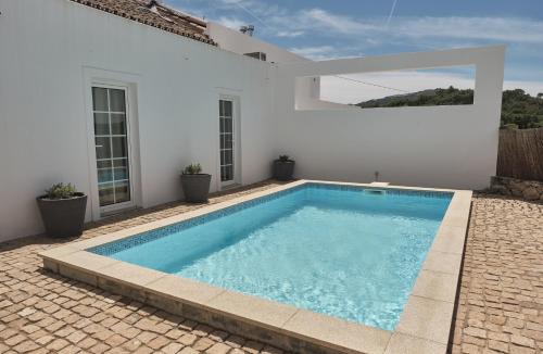 uma piscina em frente a uma casa branca em Casa do Brasão em Marvão