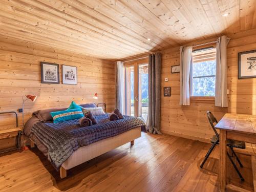 a bedroom in a log cabin with a bed and a desk at Chalet La Clusaz, 9 pièces, 13 personnes - FR-1-304-219 in La Clusaz