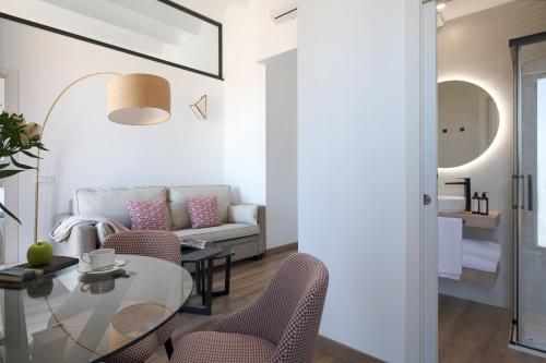 uma sala de estar com uma mesa e cadeiras e um sofá em Coliseum Boutique Apartments em Córdoba