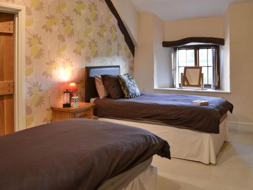 a bedroom with two beds and a window at Isobels Cottage in Chapelton