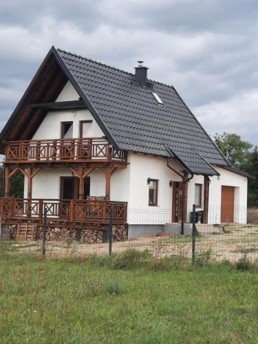 una gran casa blanca con techo negro en Mazurska Sielanka, en Orzysz