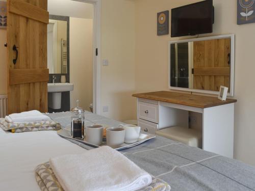 a bedroom with a bed with a table with cups and a sink at Pen Parc in Bryn-crug