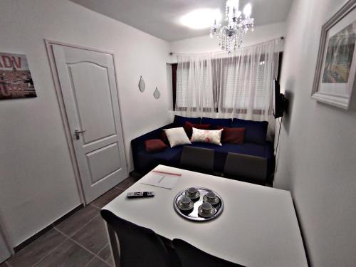 a living room with a table and a couch at Alea Apartmanok in Harkány