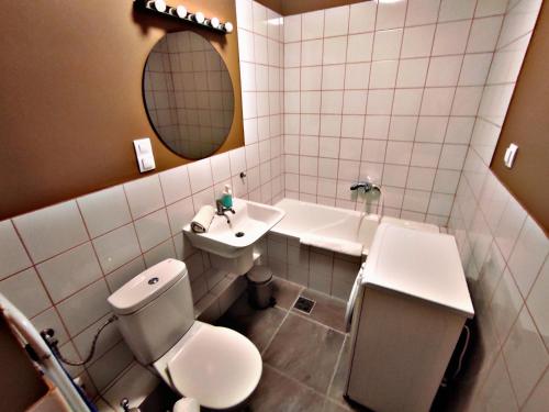 a bathroom with a toilet and a sink and a mirror at Alea Apartmanok in Harkány