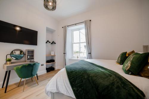 um quarto com uma cama, uma secretária e uma janela em York Place One em Harrogate
