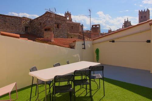 une table et des chaises sur le toit d'un bâtiment dans l'établissement LA VUE - Maison centre ville historique - Terrasse sur les toits, à Ille-sur-Têt