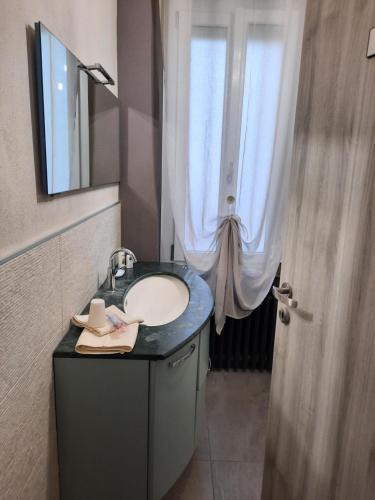 La salle de bains est pourvue d'un lavabo, d'un miroir et d'une fenêtre. dans l'établissement Villa Valentina b&b, à Vicoforte