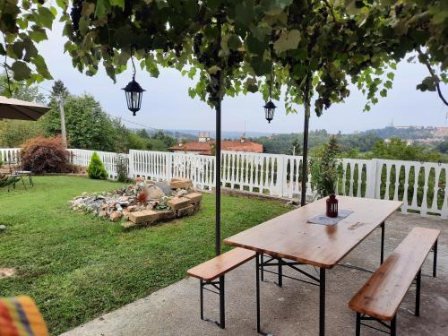 a table and benches in a yard with a fence at Villa Valentina b&b in Vicoforte