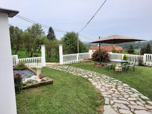 a backyard with a white fence and an umbrella at Villa Valentina b&b in Vicoforte