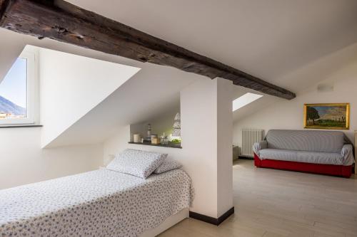 a bedroom with two beds and a couch in a attic at La mansarda sul Porto in Camogli