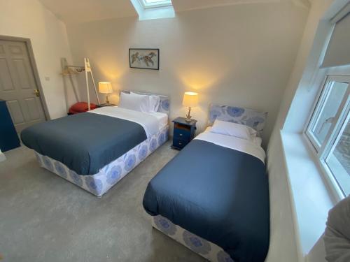1 dormitorio con 2 camas y ventana en Sanctuary Lodge en Cork