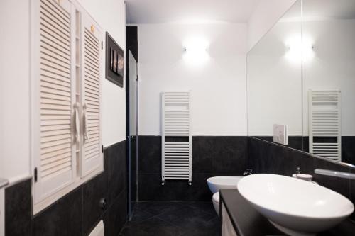 - une salle de bains en noir et blanc avec lavabo et toilettes dans l'établissement La mansarda sul Porto, à Camogli