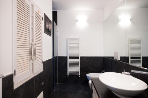 a black and white bathroom with a sink and a toilet at La mansarda sul Porto in Camogli