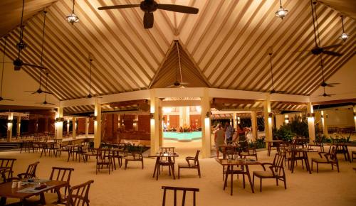 a dining room with tables and chairs in a building at Hondaafushi Island Resort in Vaikaradhoo