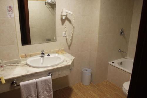a bathroom with a sink and a toilet and a phone at Arbeyal in Gijón