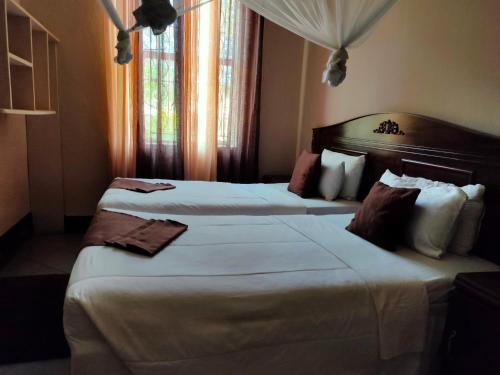 a hotel room with two beds and a window at Golden Days Lodge in Livingstone