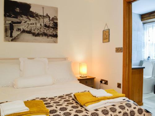 - une chambre avec un lit doté d'une couverture jaune dans l'établissement Sgubor Llwyndu, à Bettws