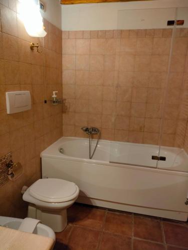 a bathroom with a white tub and a toilet at Agriturismo Fattoria Lischeto in Volterra