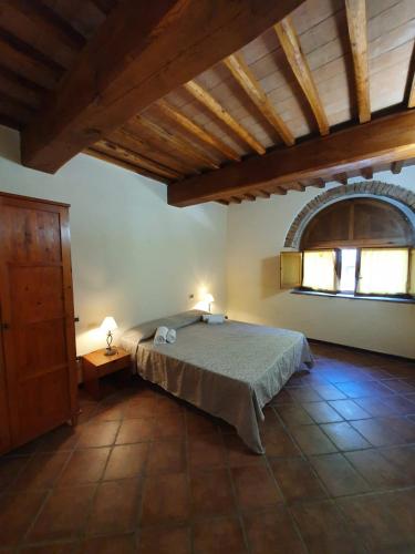 a bedroom with a bed in a room with a window at Agriturismo Fattoria Lischeto in Volterra
