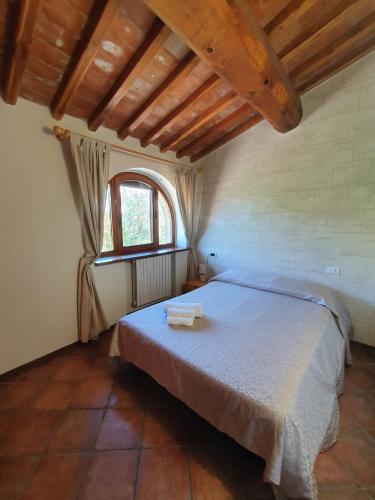 a bedroom with a large bed with a window at Agriturismo Fattoria Lischeto in Volterra