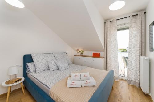 sypialnia z łóżkiem i dwoma ręcznikami na nim w obiekcie Apartament Słoneczny przy morzu z klimatyzacja w Grzybowie