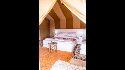a bedroom with a bed in a tent at Saharian Luxury Camp Deluxe Familly Quadriple in Merzouga