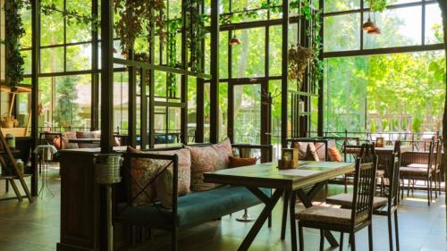 ein Restaurant mit einem Tisch, Stühlen und Fenstern in der Unterkunft VOGUE HOTEL RESORT AND SPA - Nabran in Nabran