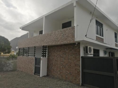 a house with a brick wall and a garage at Hortensia in Quatre Bornes