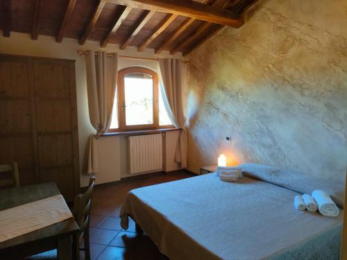 a bedroom with a bed with a candle on it at Agriturismo Fattoria Lischeto in Volterra