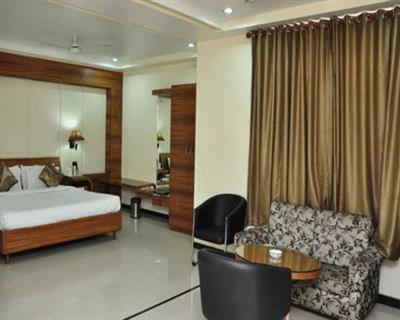 a hotel room with a bed and a couch at Simran Heritage(Business Hotel in Raipur