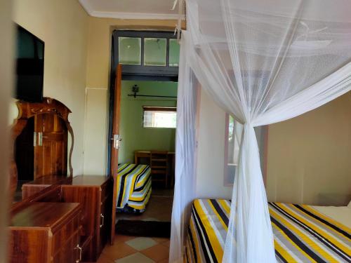 a bedroom with a bed and a dresser and a window at Golden Days Lodge in Livingstone