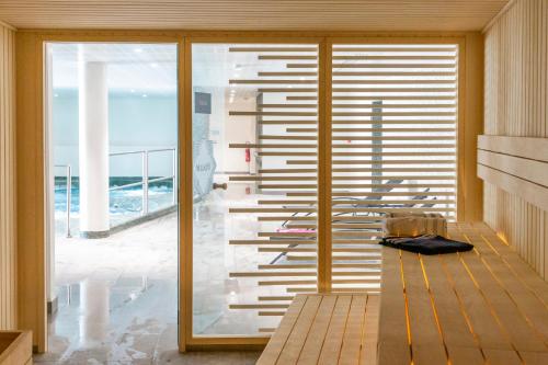 Cette chambre dispose d'une porte coulissante en verre offrant une vue sur l'océan. dans l'établissement Nemea Appart Hotel Les Hauts de Milady Biarritz, à Biarritz