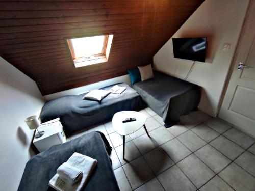 a small attic room with two beds and a couch at Alea Apartmanok in Harkány