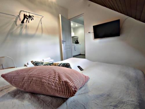 a bedroom with a bed with a television on the wall at Alea Apartmanok in Harkány
