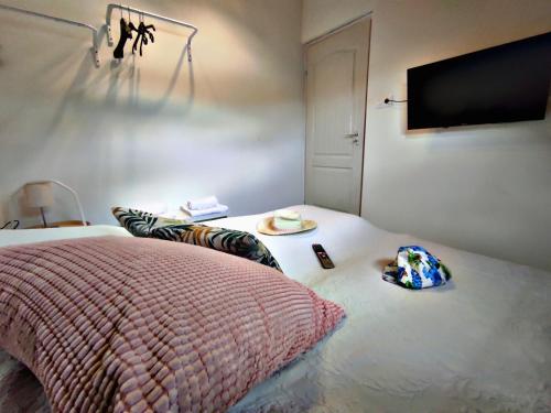 a bedroom with a bed and a flat screen tv at Alea Apartmanok in Harkány