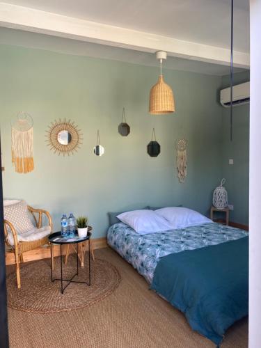 a bedroom with a bed and a table and pendant lights at Adorable chambre vue sur piscine in Béziers