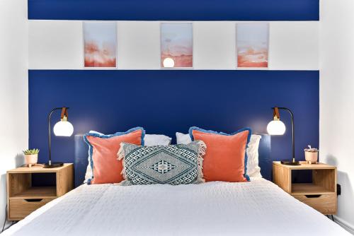 - une chambre bleue dotée d'un lit avec des oreillers orange dans l'établissement Spacious Cosy 2 Bed Flat, Central London, à Londres