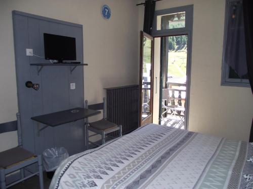 sypialnia z łóżkiem, biurkiem i telewizorem w obiekcie Hotel Valérie w mieście Montgenèvre