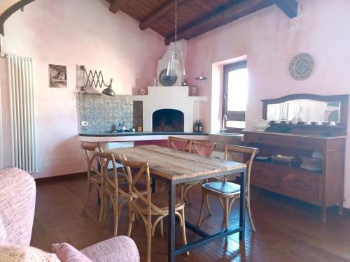 uma sala de jantar com uma mesa de madeira e cadeiras em WUNDERGARTEN Rural Spa House em Gratteri