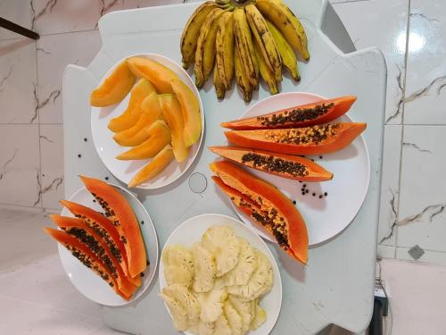einen Tisch mit Obstteller und Gemüse und ein paar Bananen in der Unterkunft Hotel Beira Mar in Natal