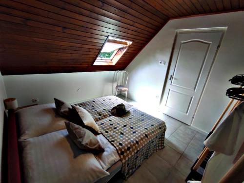 a bedroom with a bed with a wooden ceiling at Alea Apartmanok in Harkány