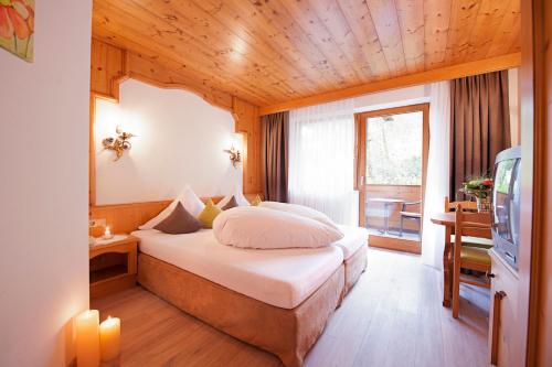 a hotel room with a bed and a television at Hotel Gasteigerhof in Neustift im Stubaital