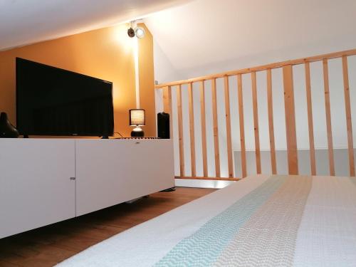 a bedroom with a flat screen tv on a white cabinet at Le Langka in Saint-Louis