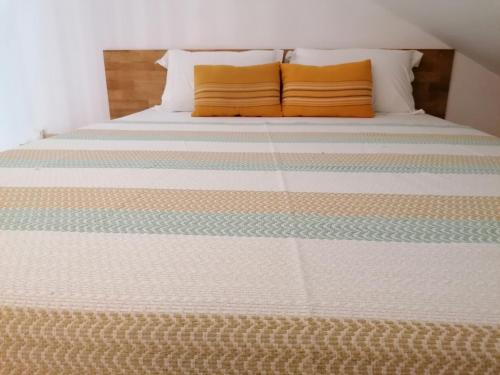 a bed with two orange pillows on top of it at Le Langka in Saint-Louis