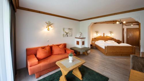 a living room with a couch and a bed at Hotel Gasteigerhof in Neustift im Stubaital